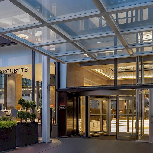 This image shows the entrance of a modern building with the name "MARQUETTE" visible inside. The area is stylish and well-lit.